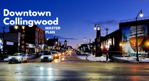 Cars drive through downtown Collingwood at dusk, with buildings and streetlights illuminated.